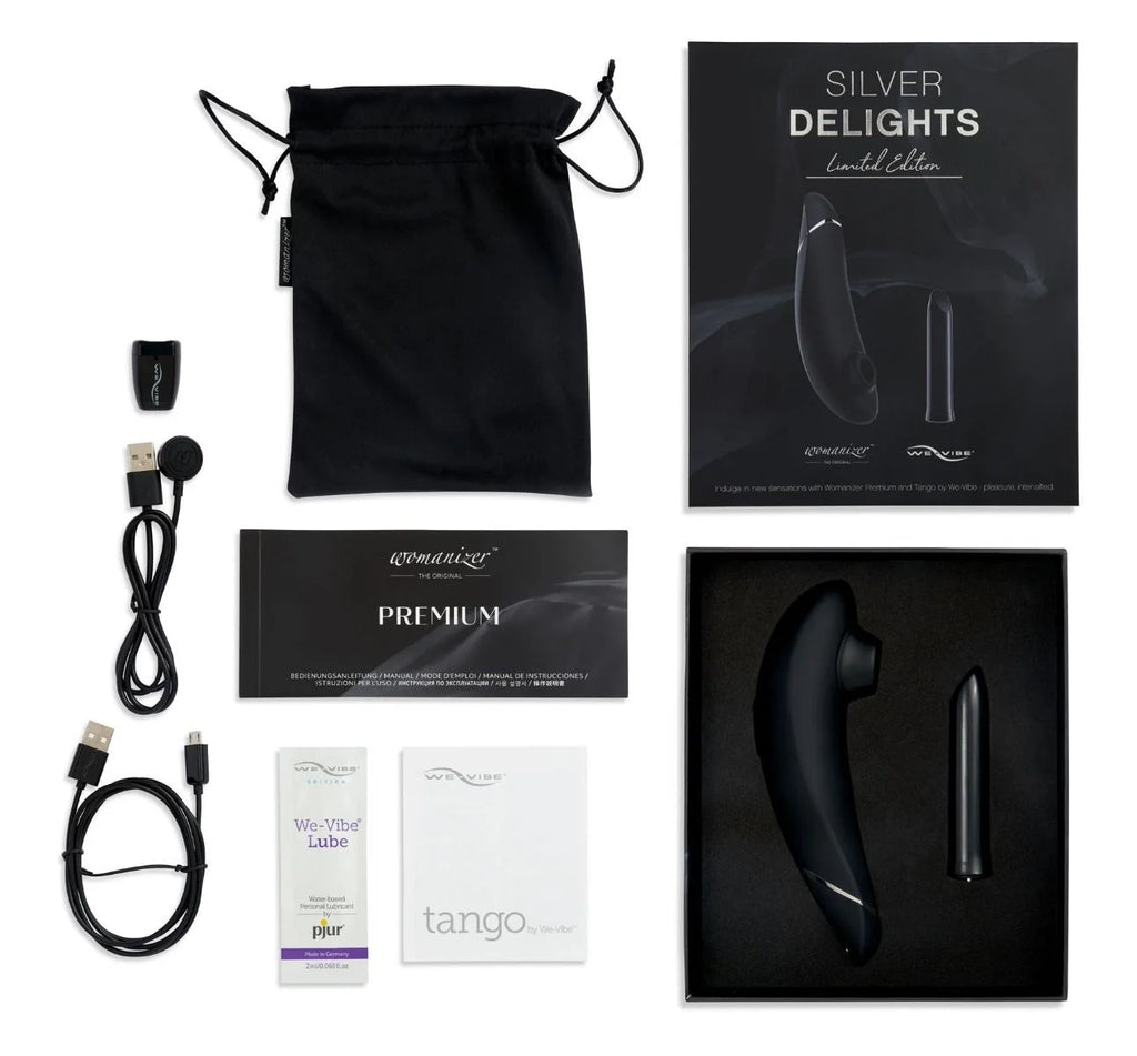 Full box contents of the We-Vibe Silver Delights set, including the We-Vibe Tango, Womanizer Premium, chargers, sample lube, carrying pouch, and manual/warranty.