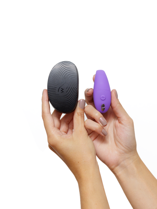 Two hands holding up vibrator and black travel case.