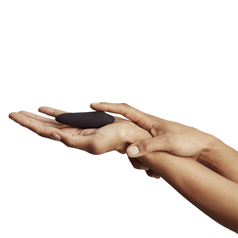 Hands holding vibrator, showing its small and compact form.